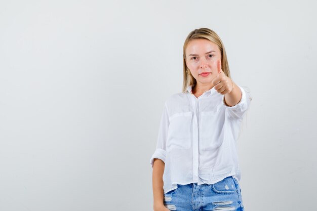 Junge blonde Frau in einem weißen Hemd