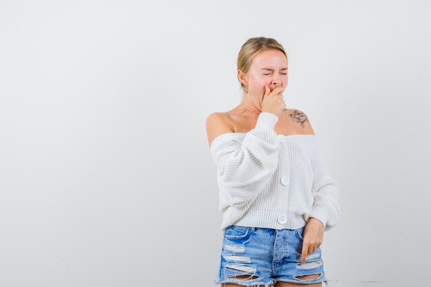 Junge blonde Frau in einem weißen Pullover