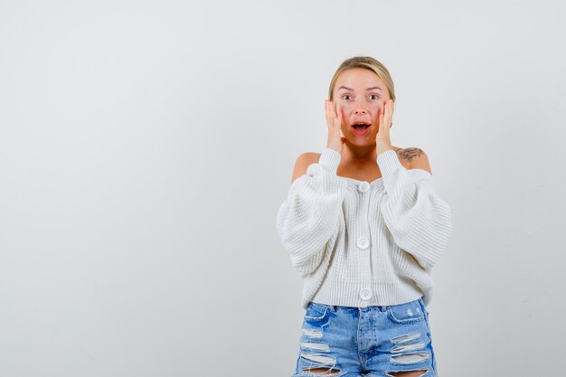 Junge blonde Frau in einem weißen Pullover