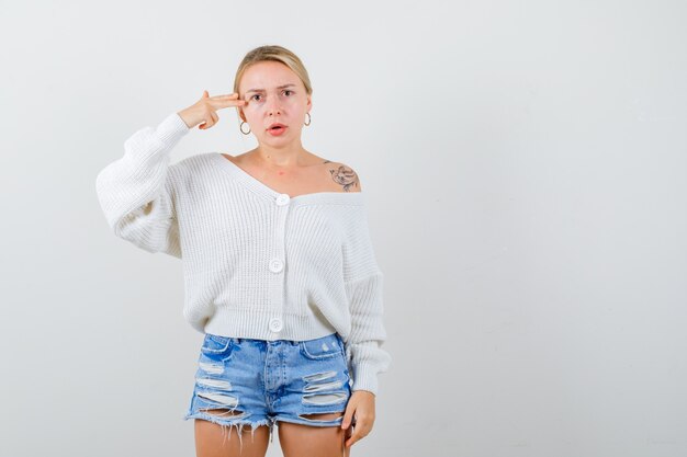 Junge blonde Frau in einem weißen Pullover