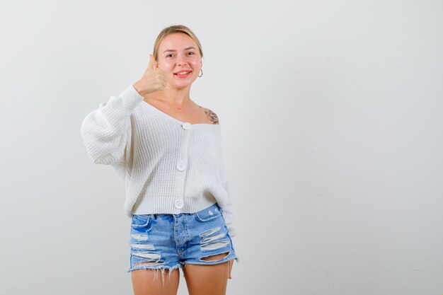 Junge blonde Frau in einem weißen Pullover