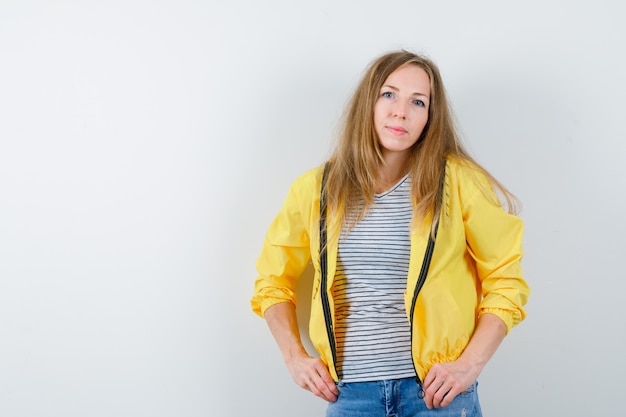 Junge blonde Frau in einer gelben Jacke