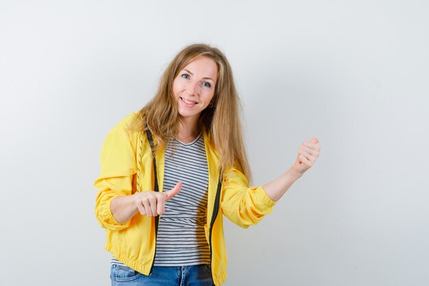 Junge blonde Frau in einer gelben Jacke