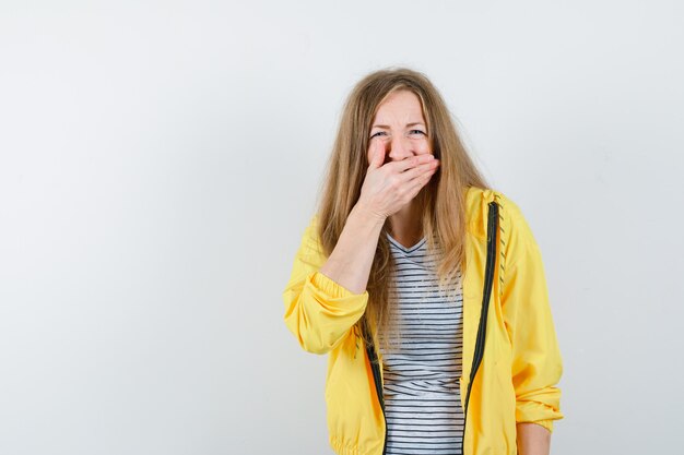 Junge blonde Frau in einer gelben Jacke