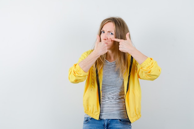 Kostenloses Foto junge blonde frau in einer gelben jacke