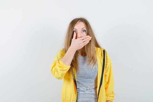 Junge blonde Frau in einer gelben Jacke