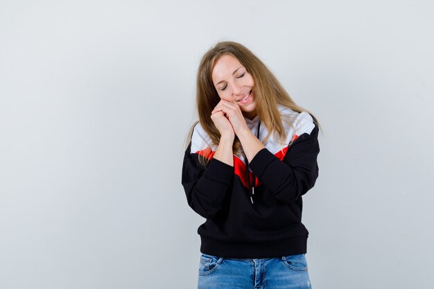 Junge blonde Frau in einer Jacke und in Jeans