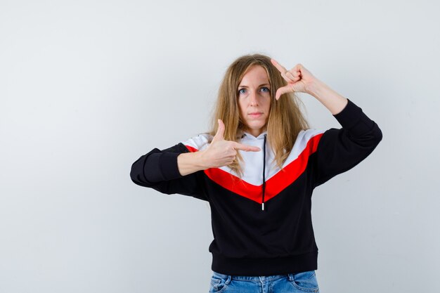 Junge blonde Frau in einer Jacke und in Jeans