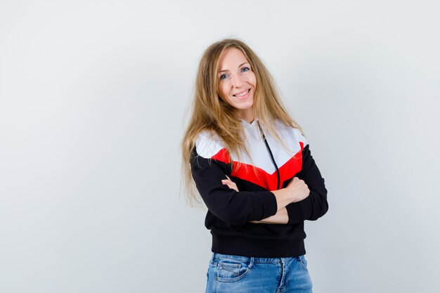 Junge blonde Frau in einer Jacke und in Jeans