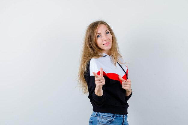 Junge blonde Frau in einer Jacke und in Jeans