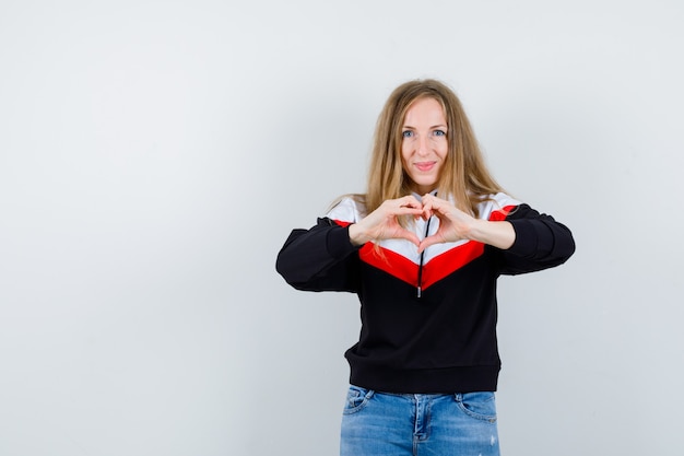 Junge blonde Frau in einer Jacke und in Jeans