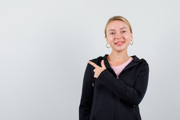 Junge blonde Frau in einer schwarzen Jacke