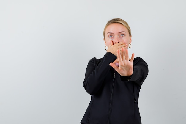 Junge blonde Frau in einer schwarzen Jacke