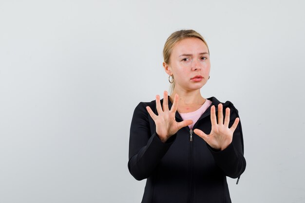 Junge blonde Frau in einer schwarzen Jacke