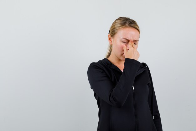 Junge blonde Frau in einer schwarzen Jacke