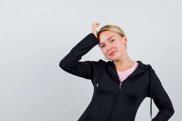 Junge blonde Frau in einer schwarzen Jacke