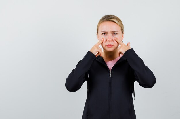 Junge blonde Frau in einer schwarzen Jacke