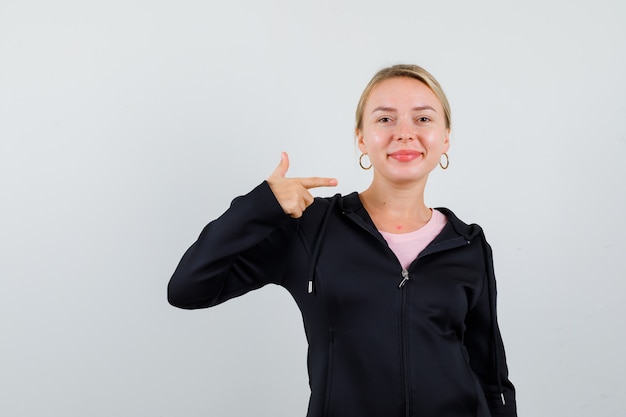 Junge blonde Frau in einer schwarzen Jacke