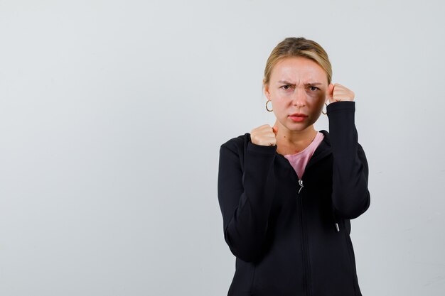 Junge blonde Frau in einer schwarzen Jacke