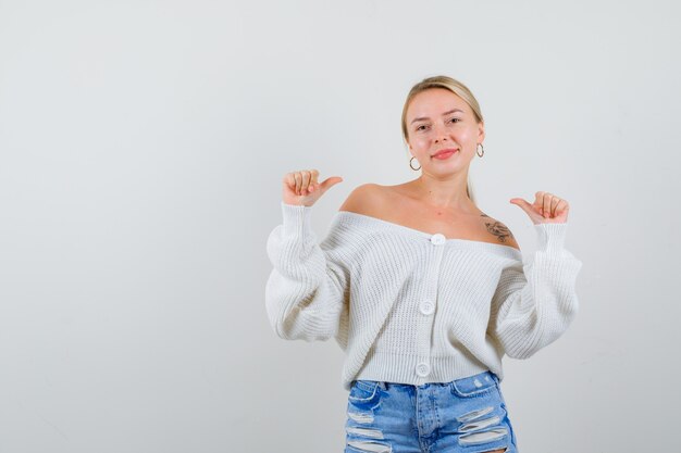 Junge blonde Frau in einer weißen Strickjacke