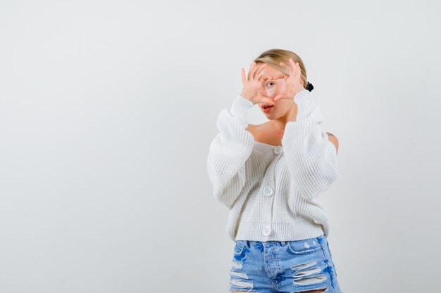 Junge blonde Frau in einer weißen Strickjacke