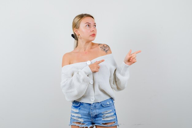 Junge blonde Frau in einer weißen Strickjacke