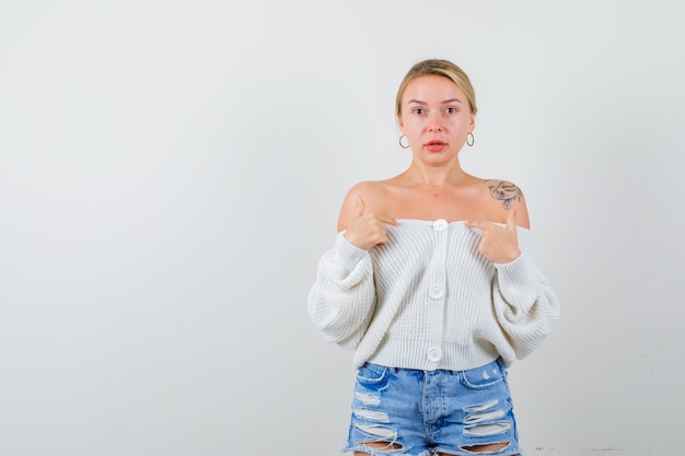 Junge blonde Frau in einer weißen Strickjacke