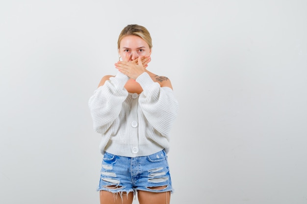 Kostenloses Foto junge blonde frau in einer weißen strickjacke