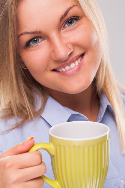 Junge blonde Frau mit Becher