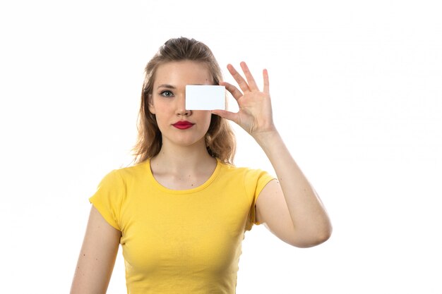 Junge blonde Frau mit gelbem T-Shirt, das leere Visitenkarte hält