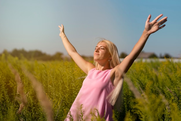 Junge blonde Frau, welche die Sonne genießt