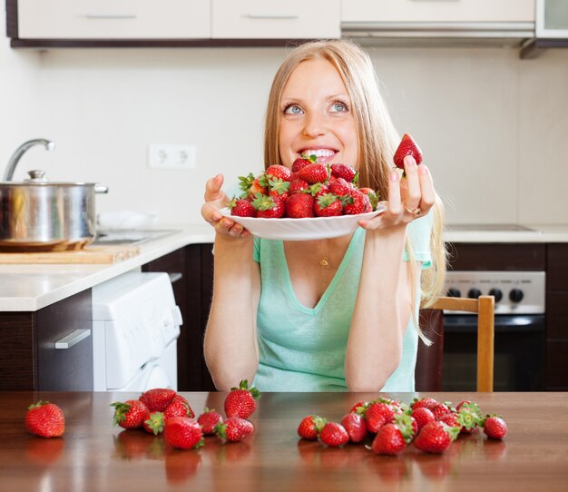 Junge blonde Hausfrau mit Erdbeeren