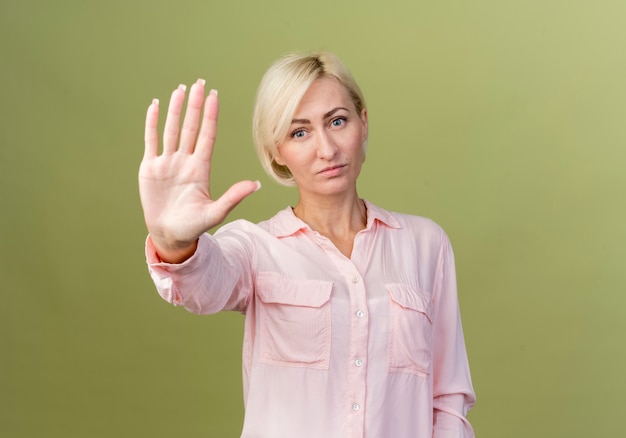 junge blonde slawische Frau, die Stoppgeste zeigt