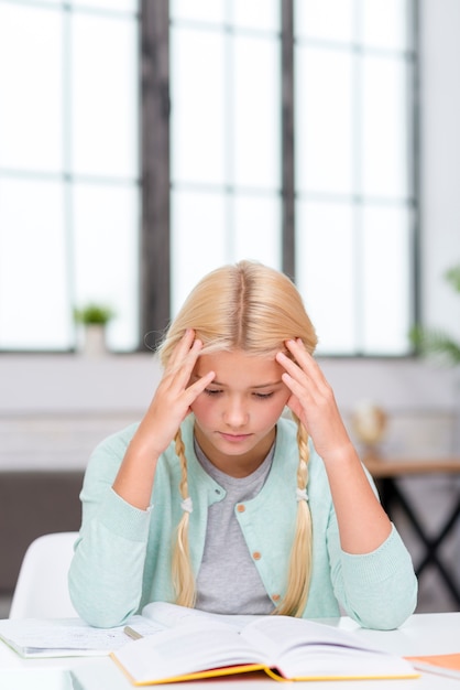 Junge blonde Studentin, die versucht, die Lektion zu verstehen