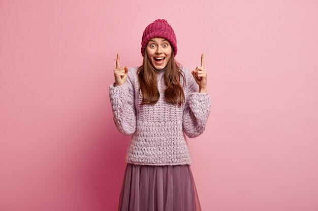 Junge brünette Frau, die bunte Winterkleidung trägt