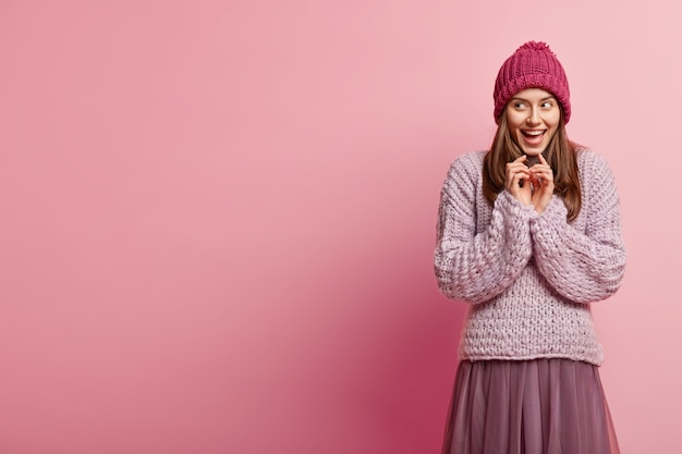 Junge brünette Frau, die bunte Winterkleidung trägt