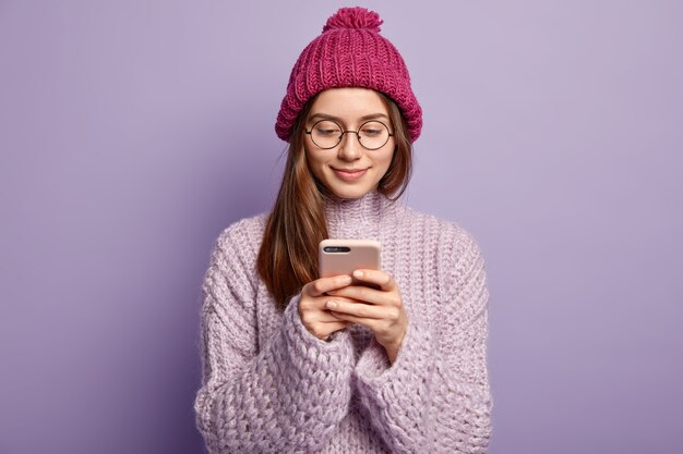 Junge brünette Frau, die lila Pullover trägt