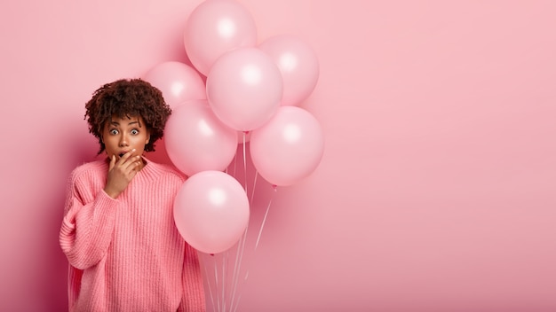 Junge brünette Frau, die Luftballons hält