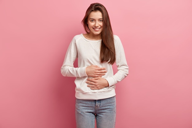 Junge brünette Frau in Jeans und Pullover