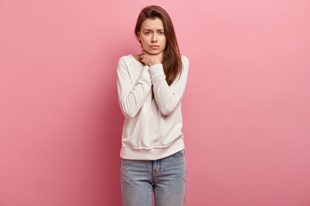 Junge brünette Frau in Jeans und Pullover