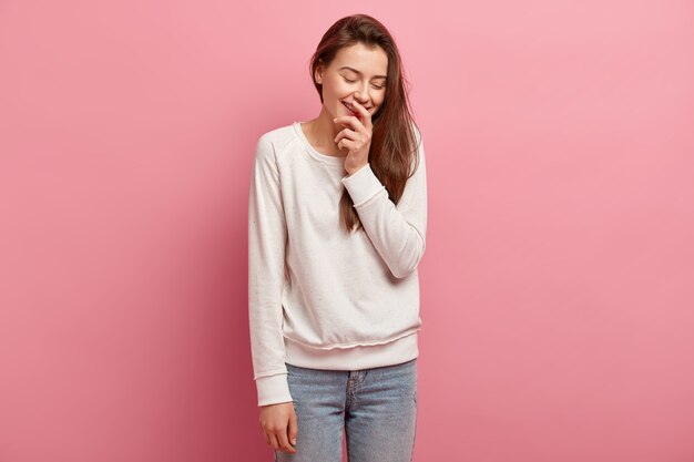 Junge brünette Frau in Jeans und Pullover