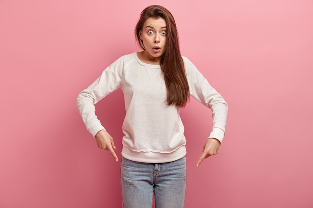 Junge brünette Frau in Jeans und Pullover