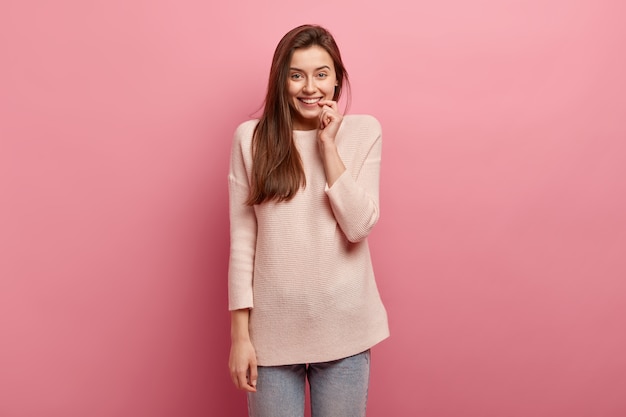 Junge brünette Frau in Jeans und Pullover