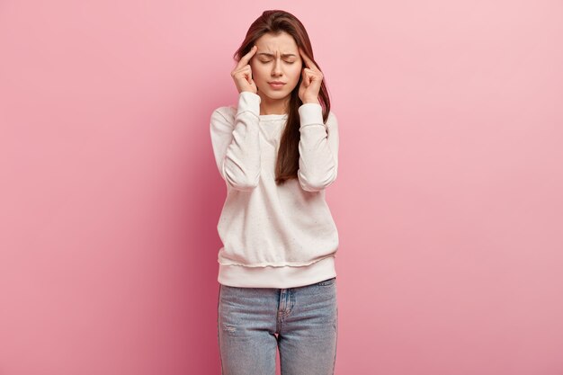 Junge brünette Frau in Jeans und Pullover