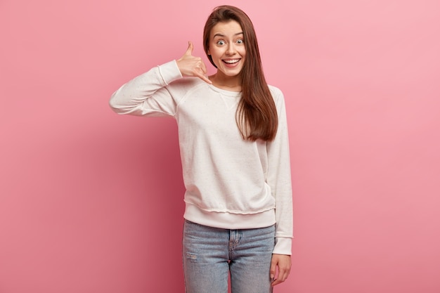 Junge brünette Frau in Jeans und Pullover