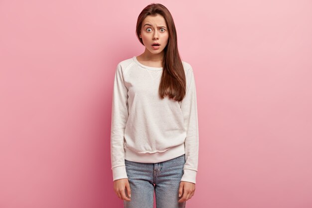 Junge brünette Frau in Jeans und Pullover