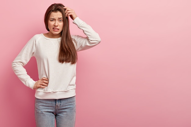 Junge brünette Frau in Jeans und Pullover