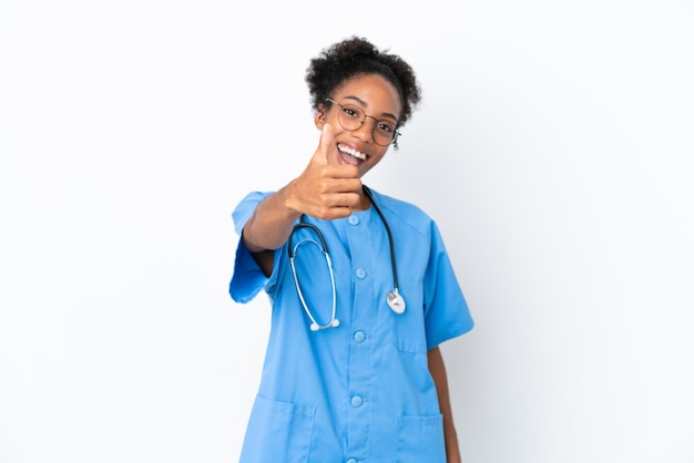 Junge chirurgin afroamerikanische ärztin isoliert auf weißem hintergrund mit daumen nach oben, weil etwas gutes passiert ist