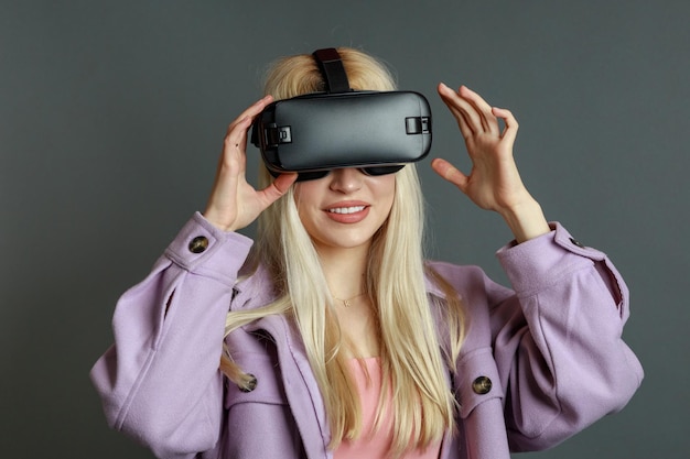 Junge Dame, die eine VR-Brille trägt und mit den Händen hält
