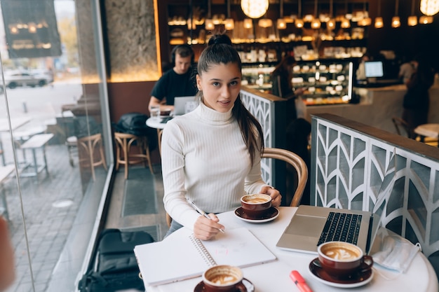 Junge Dame, die im Café im Internet surft